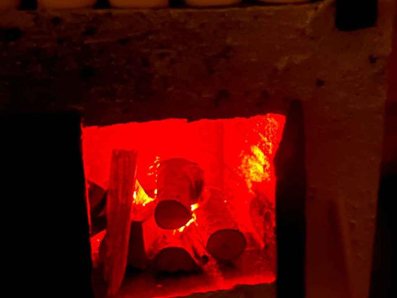 Backofen in der Backstube mit brennenden Holzscheiten